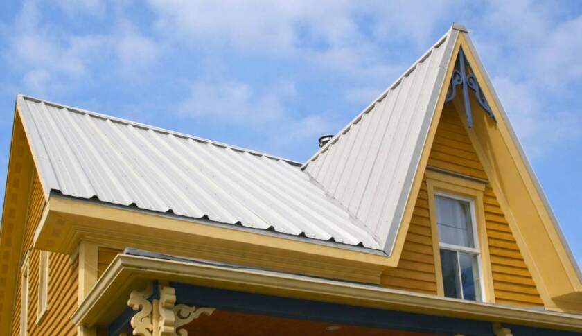 Image d'une maison avec un toit blanc en tôle.